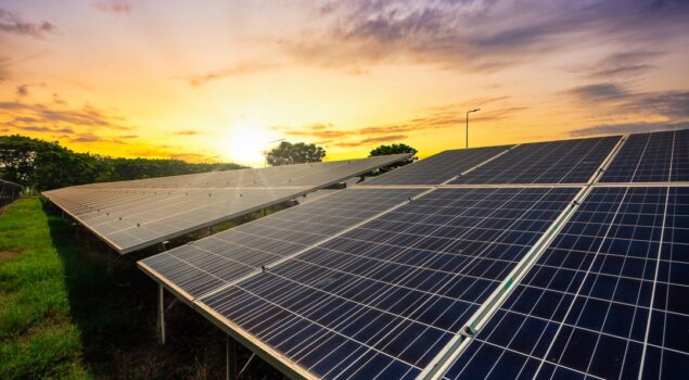 Painéis solares captando luz do sol ao entardecer, representando o uso de energia híbrida e sustentável.