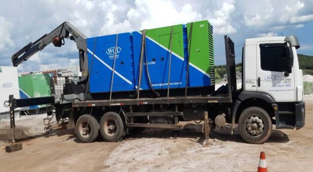 Caminhão transportando gerador industrial para instalação em obra, ilustrando a decisão entre alugar ou comprar gerador para garantir energia sem interrupções.