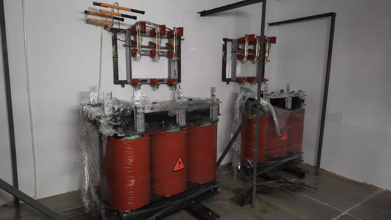 Transformadores elétricos instalados em ambiente técnico, destinados à distribuição e proteção de sistemas elétricos.