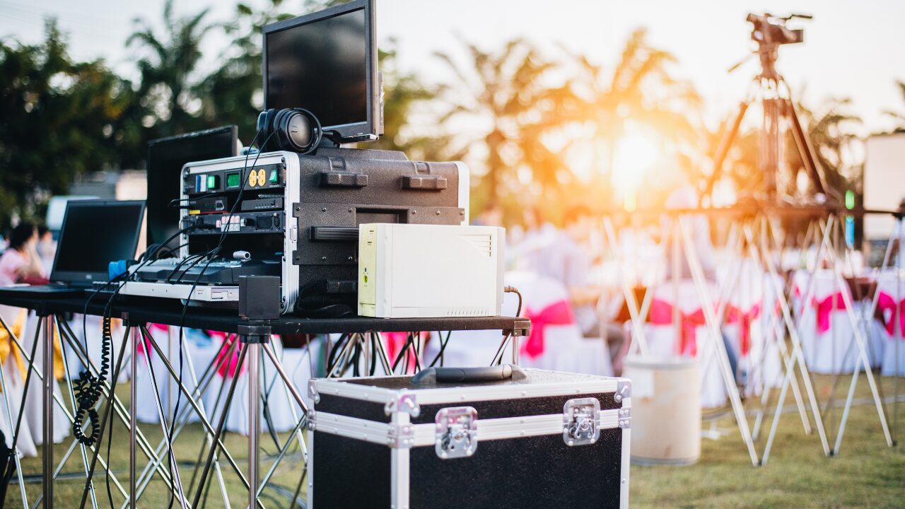 Equipamentos de áudio, vídeo e transmissão instalados para dar suporte técnico a um evento ao ar livre.